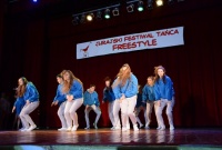 Zespół w niebiesko-białych barwach tańczy na scenie