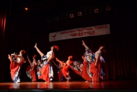 Dziewczyny w długich sukniach unoszą jedną noge do góry