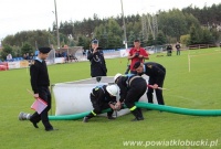 Zawodnicy próbują przykręcić wąż strażackich podczas konkurencji