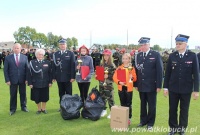 Trzy zawodniczki w towarzystwie straży prezentuje dyplomy i puchary